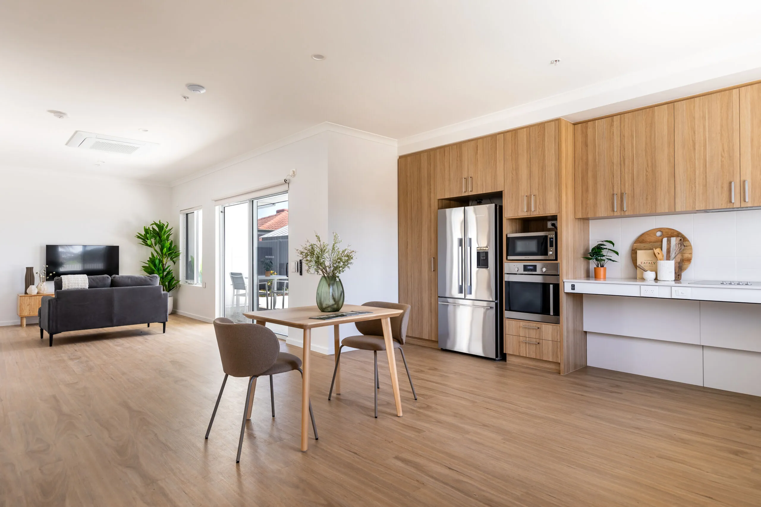 A kitchen and loungeroom in a house