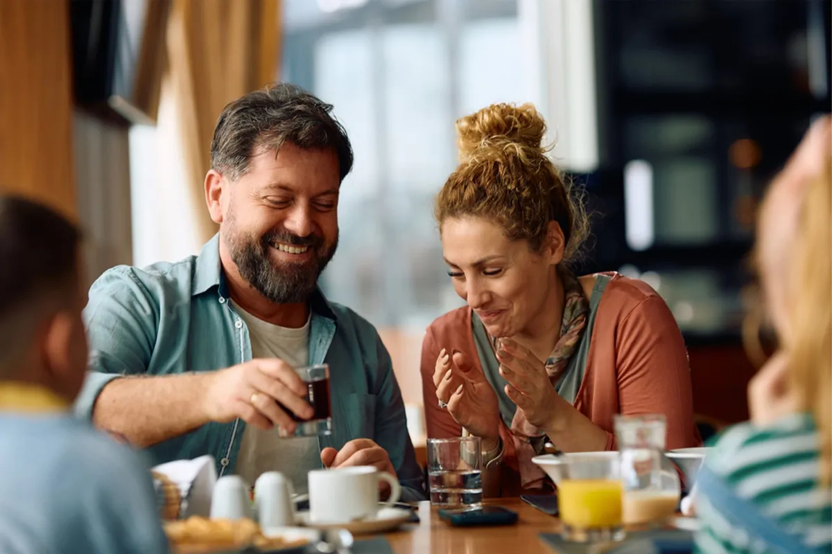 Happy parents having fun while eating breakfast